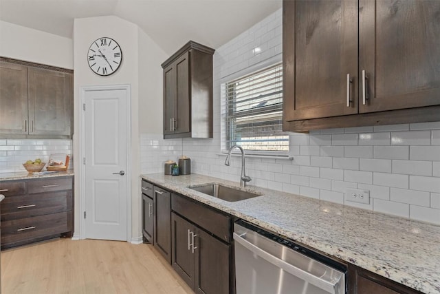 kitchen featuring dark brown cabinetry, dishwasher, lofted ceiling, and a sink