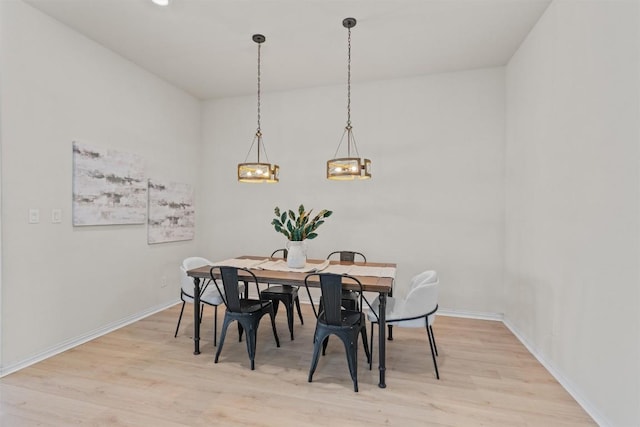 dining area with wood finished floors, baseboards, and a chandelier