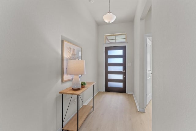 foyer entrance featuring baseboards and light wood finished floors