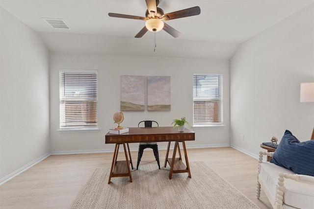 office space with baseboards, visible vents, light wood finished floors, ceiling fan, and vaulted ceiling