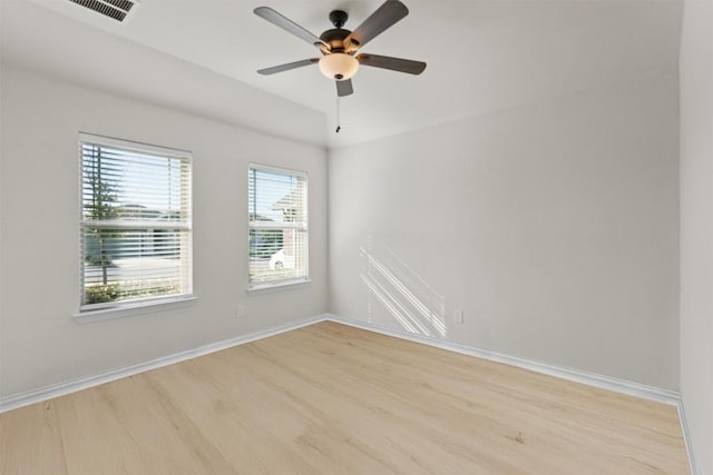 unfurnished room with ceiling fan, visible vents, baseboards, and wood finished floors