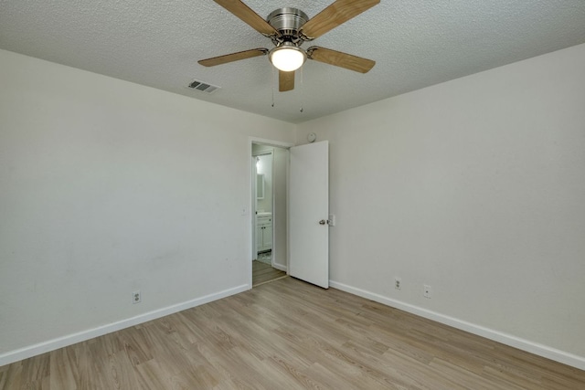 spare room with visible vents, baseboards, and light wood-style floors