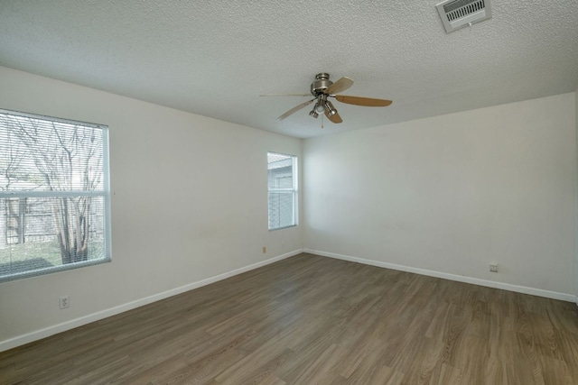 unfurnished room with visible vents, wood finished floors, baseboards, and ceiling fan