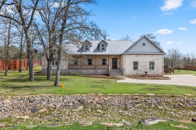 view of front of house featuring fence, a porch, concrete driveway, a front yard, and stone siding