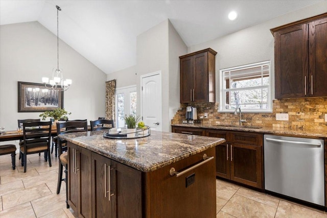 kitchen with a sink, decorative light fixtures, dark stone countertops, stainless steel dishwasher, and a center island