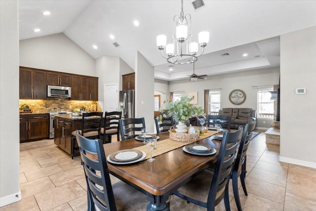 dining room with light tile patterned floors, visible vents, a raised ceiling, and baseboards