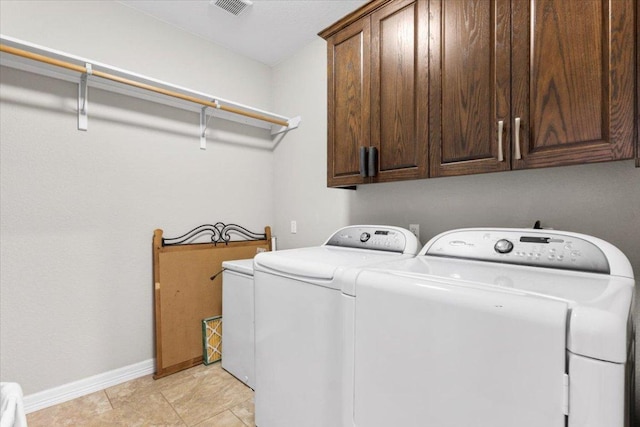 washroom featuring light tile patterned floors, visible vents, baseboards, cabinet space, and washer and clothes dryer