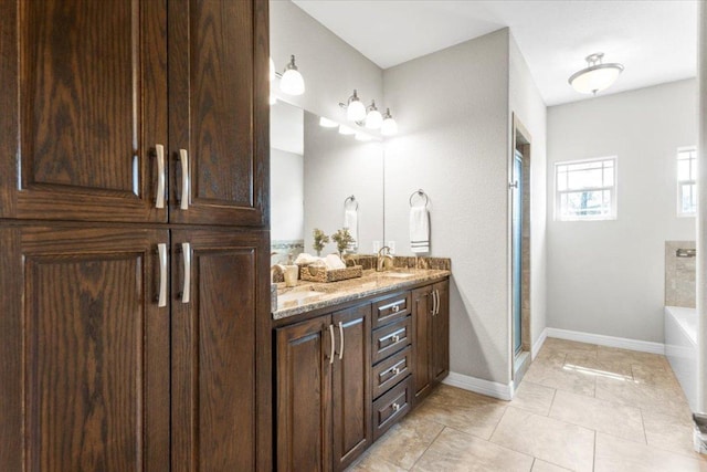 full bath with tile patterned floors, a stall shower, a sink, baseboards, and a bath