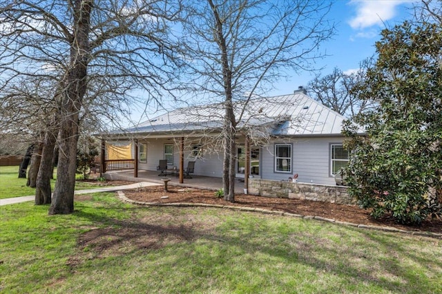 rear view of house with an attached carport, a lawn, a chimney, a patio area, and driveway