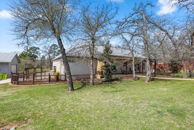 view of yard with an outdoor structure, a patio area, a garage, and a wooden deck