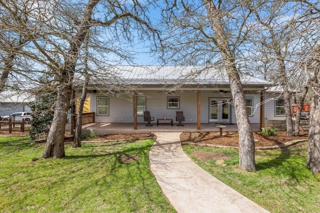 rear view of property with a lawn, a patio, fence, metal roof, and ceiling fan