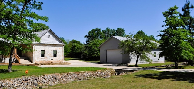 151 William Higgins Dr, Bastrop, TX 78602 - view of front facade with stone siding, a front yard, an outdoor structure, and a detached garage