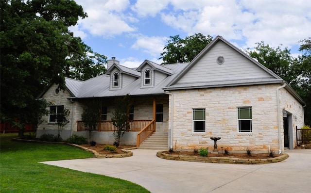 151 William Higgins Dr, Bastrop, TX 78602 - view of front of home with stone siding, a porch, a chimney, and concrete driveway