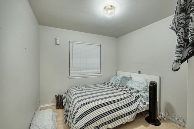 bedroom with light wood-type flooring and baseboards