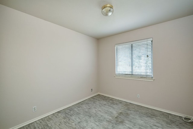 empty room with wood finished floors and baseboards