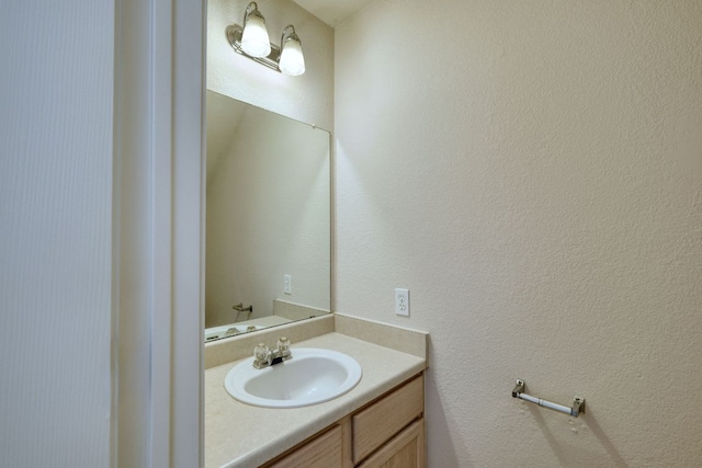 bathroom with vanity and a textured wall