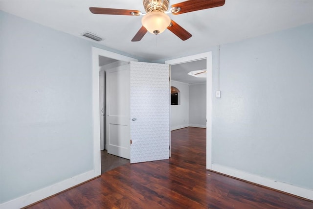 unfurnished room with ceiling fan, visible vents, baseboards, and wood finished floors