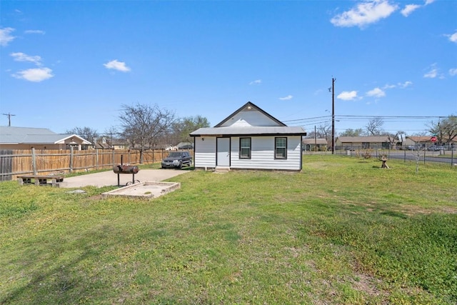 rear view of house featuring a yard and fence