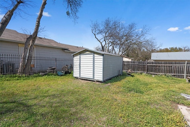 view of yard with a fenced backyard, a storage unit, and an outdoor structure