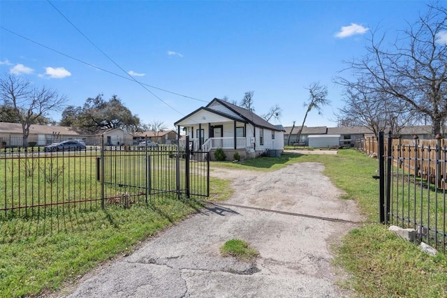 bungalow-style home featuring a fenced front yard, driveway, and a front yard