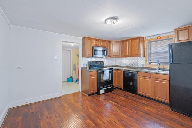 kitchen featuring black appliances, a sink, backsplash, dark wood finished floors, and baseboards