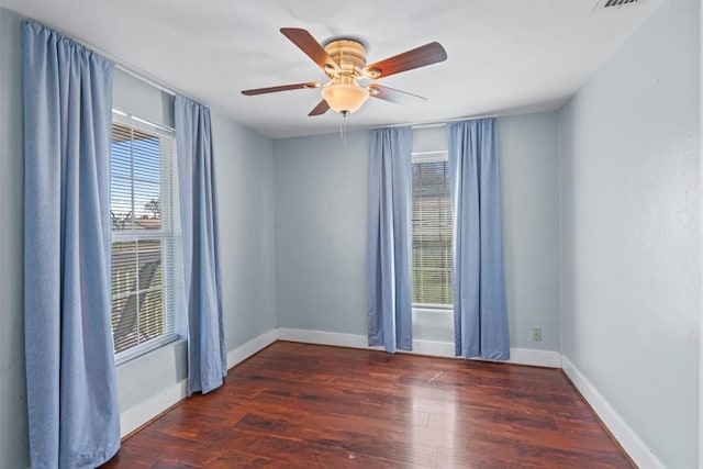 spare room featuring visible vents, wood finished floors, baseboards, and ceiling fan