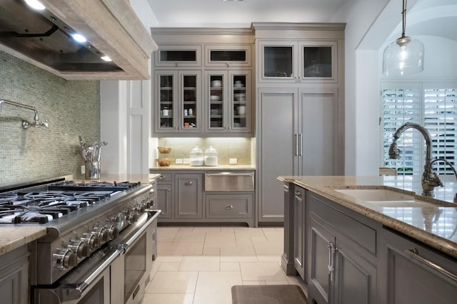 kitchen featuring double oven range, gray cabinets, wall chimney exhaust hood, a warming drawer, and a sink