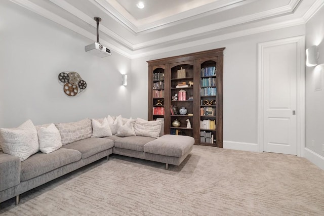 carpeted living area with baseboards, a tray ceiling, and ornamental molding