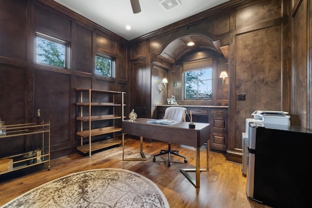 office space featuring visible vents, light wood-style floors, a healthy amount of sunlight, and a ceiling fan