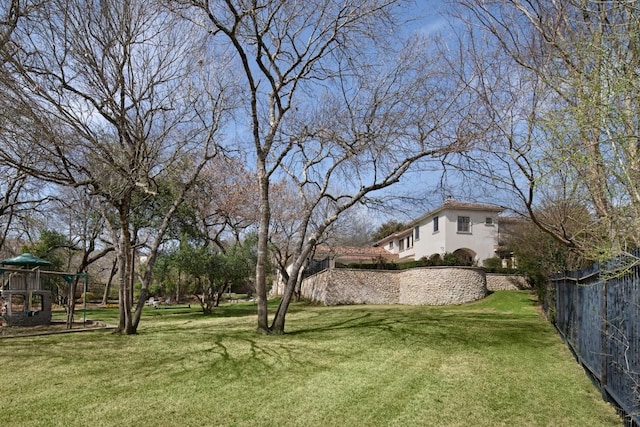 view of yard with fence and a playground