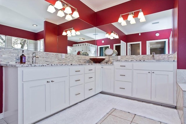 bathroom featuring double vanity, a sink, tile patterned flooring, ornamental molding, and backsplash