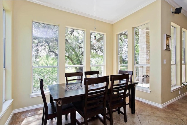 tiled dining space featuring crown molding and baseboards