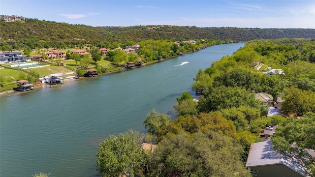 birds eye view of property with a wooded view and a water view