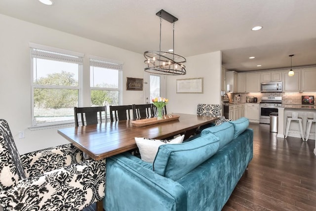 dining room featuring a chandelier, recessed lighting, and dark wood-type flooring