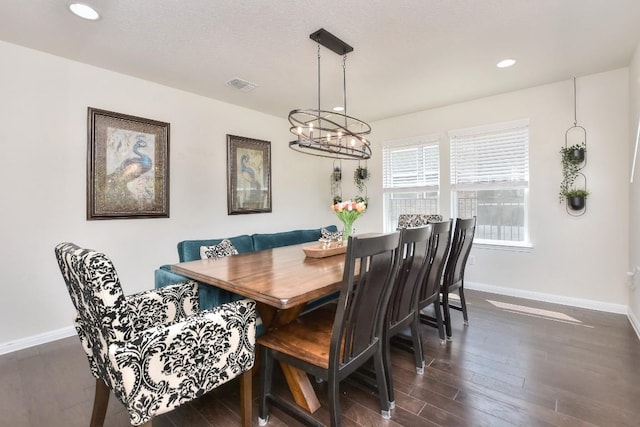 dining area featuring a notable chandelier, baseboards, visible vents, and dark wood-style flooring