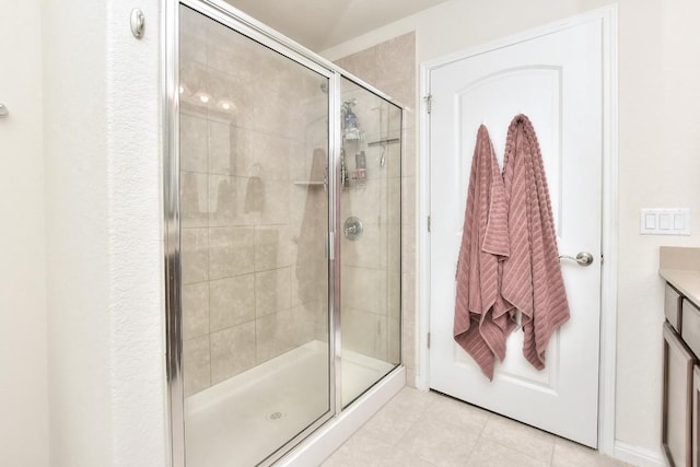 full bath with tile patterned floors, a stall shower, and vanity