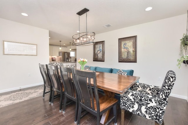 dining area featuring dark wood finished floors, an inviting chandelier, baseboards, and visible vents