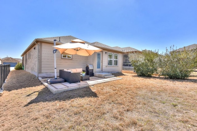 rear view of property featuring a patio area, fence, and a lawn