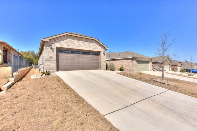 ranch-style house featuring brick siding, concrete driveway, and fence