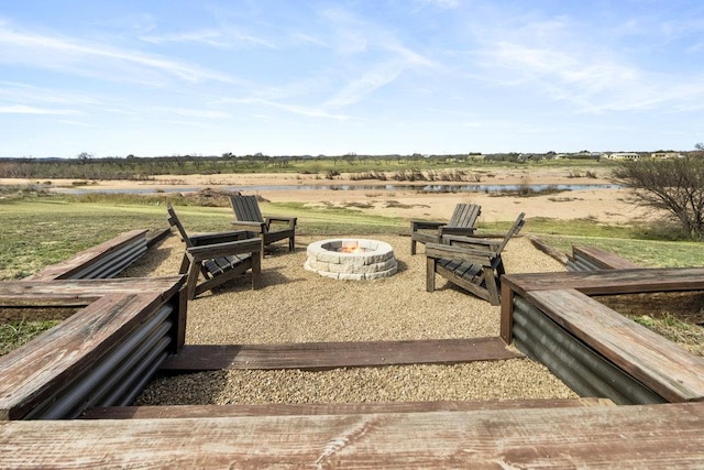 view of yard with a water view, a rural view, and an outdoor fire pit