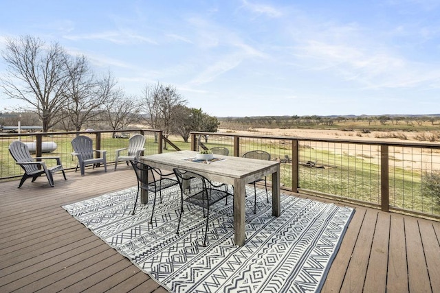 wooden deck with outdoor dining area and a yard