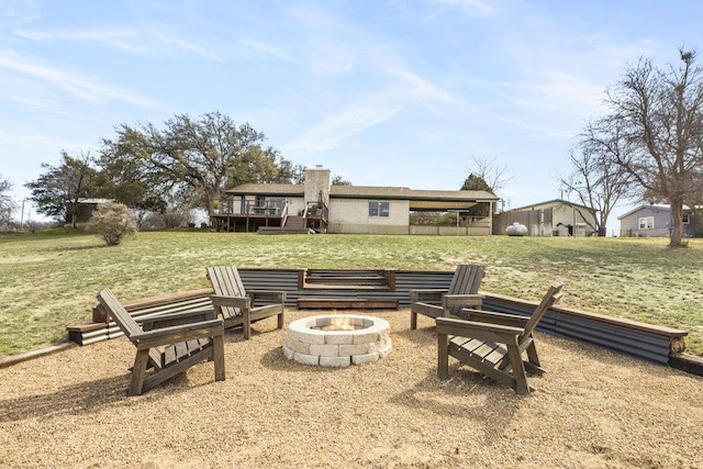 view of yard with a deck and an outdoor fire pit