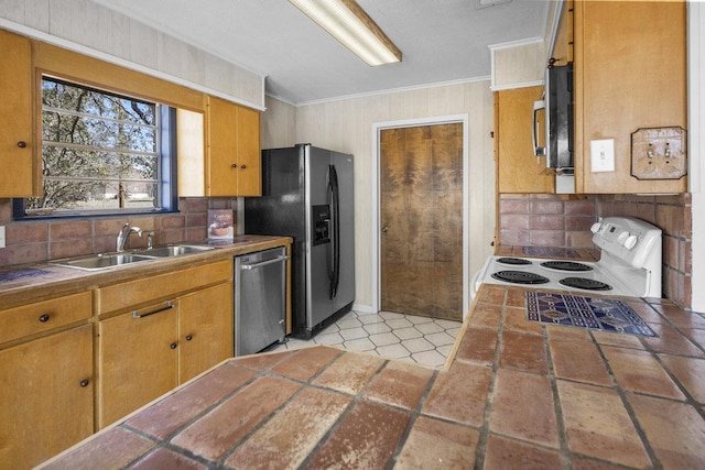 kitchen featuring tile counters, ornamental molding, decorative backsplash, stainless steel appliances, and a sink