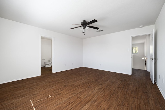 empty room with dark wood-style floors, visible vents, baseboards, and a ceiling fan