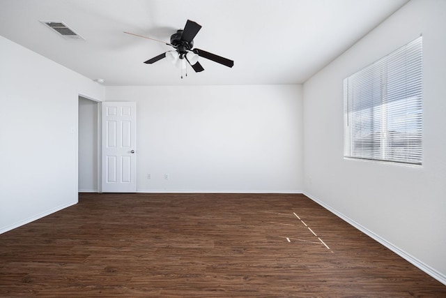 spare room with dark wood-type flooring, baseboards, and visible vents