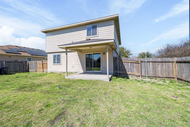 rear view of house featuring a yard, a patio, and a fenced backyard