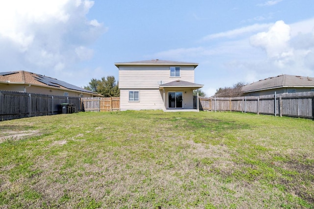 back of property with a lawn and a fenced backyard