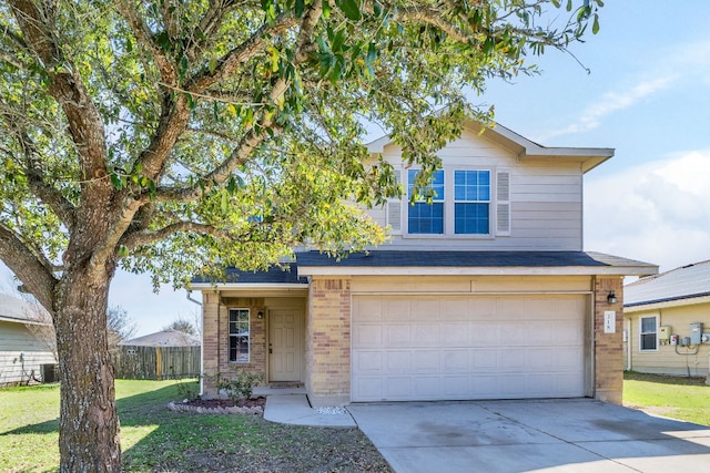 traditional home with a front lawn, fence, concrete driveway, a garage, and brick siding