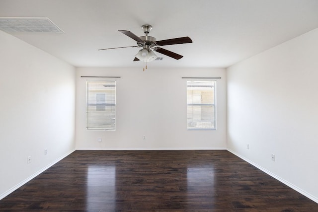 empty room featuring baseboards, wood finished floors, visible vents, and ceiling fan