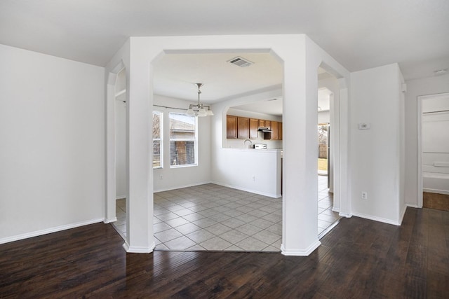 interior space featuring visible vents, baseboards, an inviting chandelier, and wood finished floors